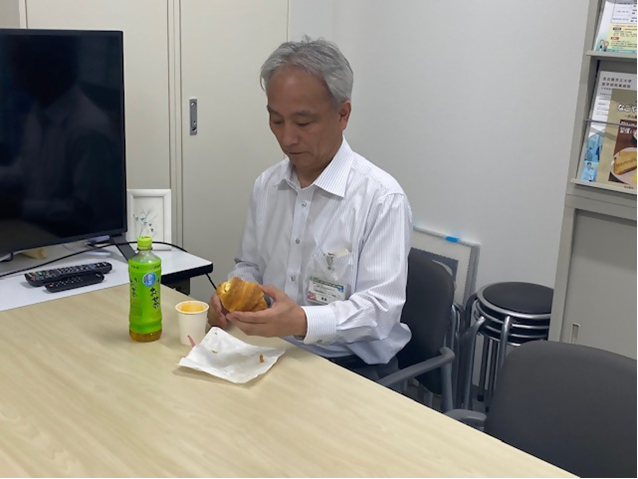 山田所長が職員と昼食をとる様子